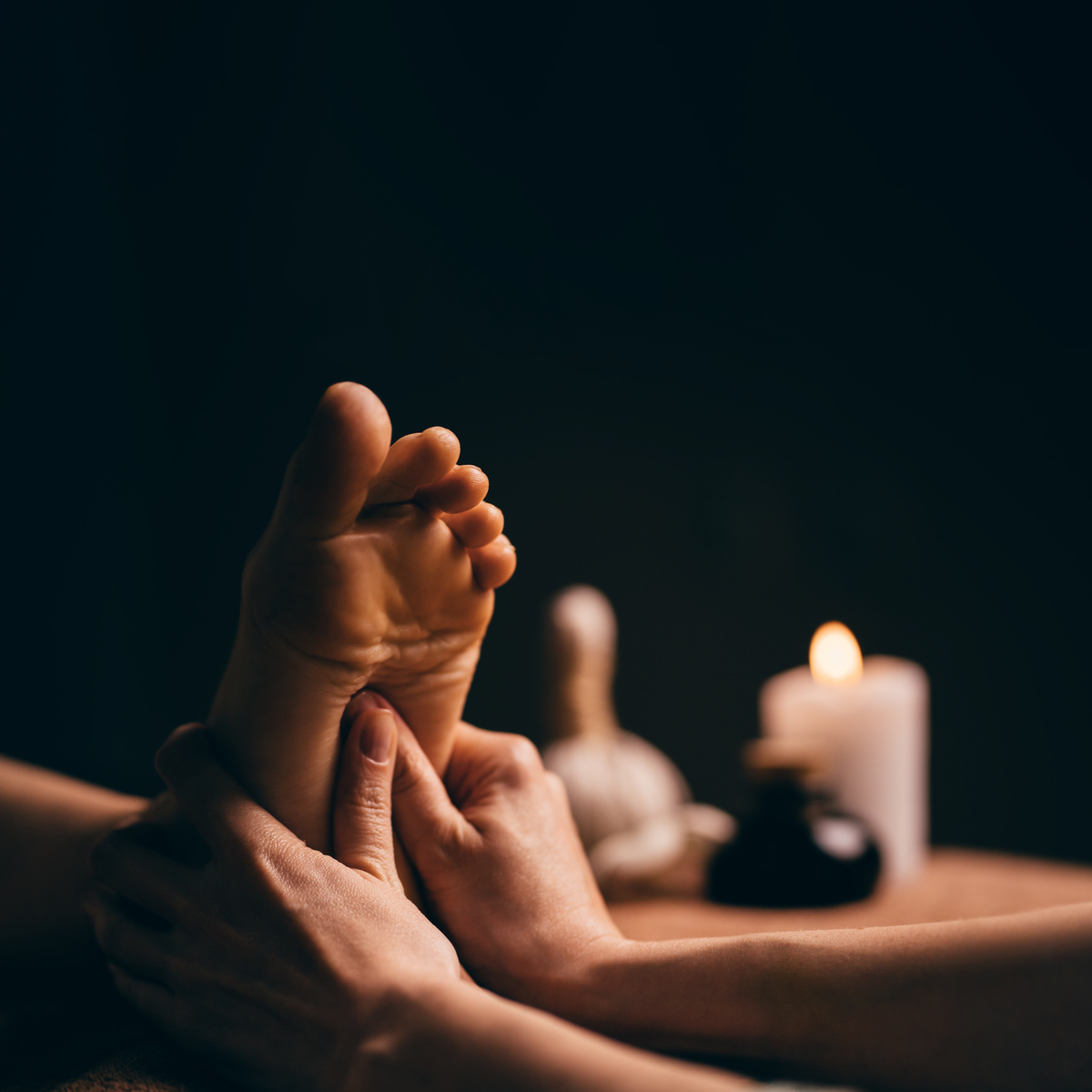 Professional foot massage close up. Authentic shot of luxury spa treatment. Charming light. Shallow depth of field. Stylized and colored.